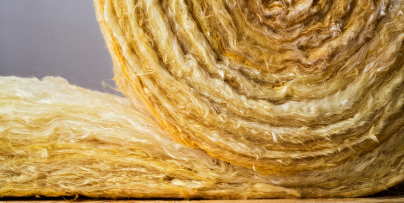 Rotolo di lana minerale utilizzato per l'isolamento termico, con fibre visibili in primo piano.